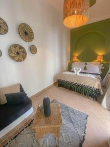 Riad Dar Marrakcha في مراكش: غرفة نوم بسرير واريكة وطاولة