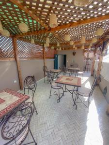 un grupo de mesas y sillas en una habitación en Riad Dar Marrakcha, en Marrakech