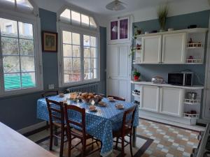 a kitchen with a table with a blue table cloth at Maison Violette en Berry in Aigurande