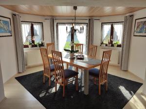 a dining room with a table and chairs and windows at Gästewohnung Mühlstein in Hohenthann
