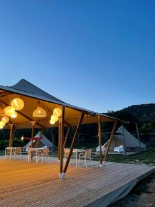 una terraza de madera con mesas, sillas y tiendas de campaña en Quinta da Boa Sorte en Estói