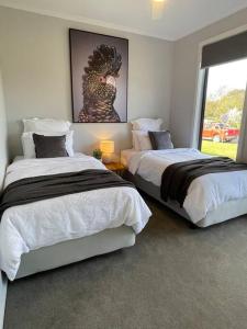 a bedroom with two beds and a picture of a chicken on the wall at Modern home away from home in Mansfield
