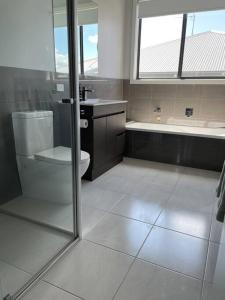 a bathroom with a toilet and a sink and a shower at Modern home away from home in Mansfield