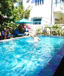 Dos personas están jugando en una piscina en Hoi An Mountain House Villa, en Hoi An