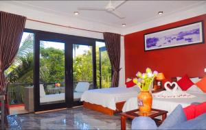 a bedroom with red walls and a bed and a balcony at Hoi An Mountain House Villa in Hoi An