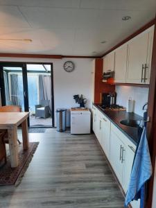 a kitchen with white cabinets and a table and a counter top at Chalet M & J in Heel