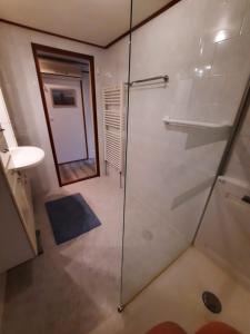 a bathroom with a glass shower and a sink at Chalet M & J in Heel