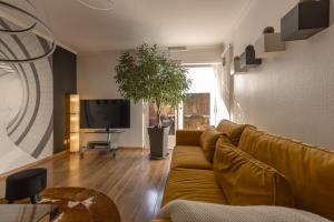 sala de estar con sofá y TV de pantalla plana en Le gîte de Sabina - Colmar, en Colmar