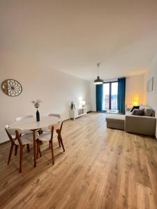 a living room with a table and chairs and a couch at Apartamenty Przy Rynku Trzebnica in Trzebnica