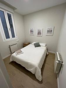 a bedroom with a large white bed and a window at MyHouseSpain - Acogedor piso con patio en Chamberi in Madrid