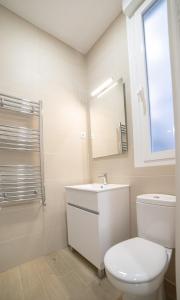 a white bathroom with a toilet and a sink at MyHouseSpain - Acogedor piso con patio en Chamberi in Madrid