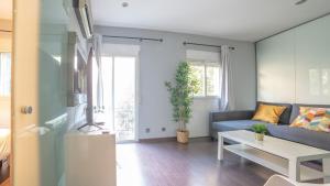sala de estar con sofá azul y mesa en MyHouseSpain - Moderno apartamento a escasos metros del Bernabeu en Madrid