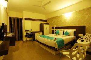 a bedroom with a large bed and a table and chairs at moriz inn in Mysore