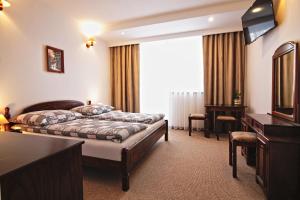 um quarto de hotel com duas camas e uma televisão em Motel Na Zbójeckiej em Skawa