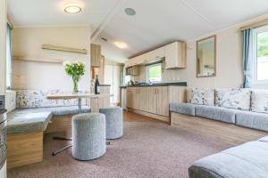 a caravan kitchen and living room with a table and chairs at Beachside caravan in Mablethorpe