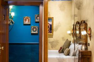 a room with a blue wall with a bed and framed pictures at Hotel Palazzo Priuli in Venice