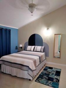 1 dormitorio con 1 cama grande y pared azul en Comfy Seascape Retreat near Kingston Airport, en Kingston