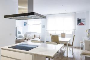 a kitchen and living room with a table and chairs at MyHouseSpain - Piso en centro Gijón a pocos minutos de las playas in Gijón