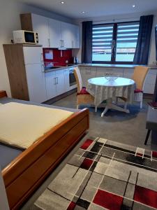 Habitación con cama, mesa y cocina. en Cafe und Pension Ringer en Vilseck