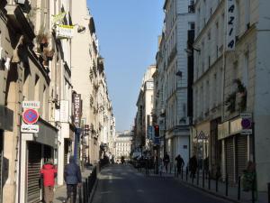 a city street with people walking down the street at Royale 3 Bedroom, 2 Bathroom Apartment With AC - Louvre in Paris