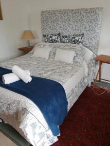 um quarto com uma cama grande e toalhas em The Little Cottages em Howick