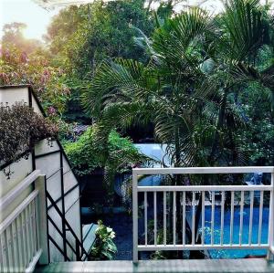 une porte blanche avec des palmiers dans un jardin dans l'établissement Marari Dreamz Homestay, à Mararikulam