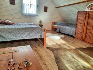 Schlafzimmer im Dachgeschoss mit 2 Betten und einem Fenster in der Unterkunft Chata Panorama in Stróża