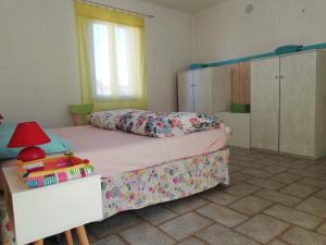 1 dormitorio con 1 cama y 1 mesa con lámpara en Da Simona- casa 4 posti letto + 4 aggiuntivi en Arona