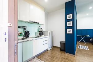 SETAPAK CENTRAL KL-zeta suite by ALOHA في كوالالمبور: مطبخ فيه دواليب بيضاء وحائط ازرق