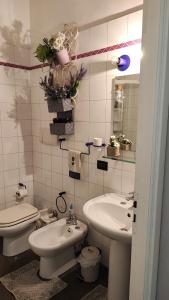 a bathroom with two sinks and a toilet and a mirror at In centro da Laura, Via Repubblica 49 BI in Biella