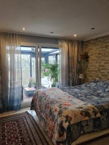 a bedroom with a bed and a large window at Cozy room with a beautiful garden view in Baunatal