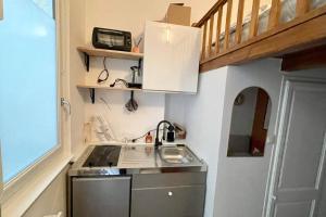 uma pequena cozinha com um lavatório e uma escadaria em Charmant cocon au cœur de Dijon em Dijon