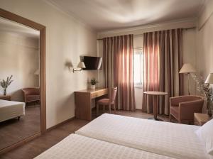 a hotel room with a bed and a desk at Strada Marina Hotel in Zakynthos