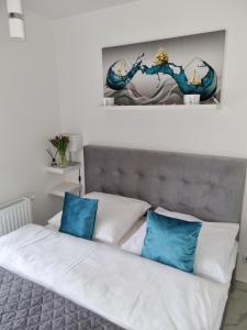 een slaapkamer met een bed met blauwe en witte kussens bij Apartament DoriSun-Lighthouse Mrzeżyno in Mrzeżyno
