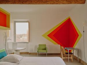 een slaapkamer met een bed en een tafel en stoelen bij Domaine La Ferme HI bride in Villelaure