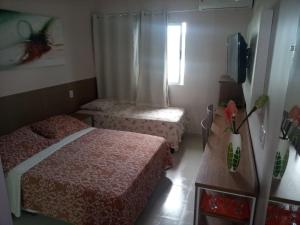 a small bedroom with two beds and a window at Apart Hotel Marinas Vista para o Mar Praia dos Carneiros in Tamandaré +31 photos