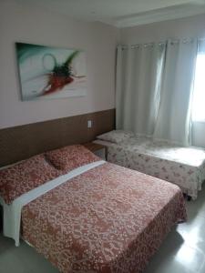 a bedroom with two beds and a window at Apart Hotel Marinas Vista para o Mar Praia dos Carneiros in Tamandaré