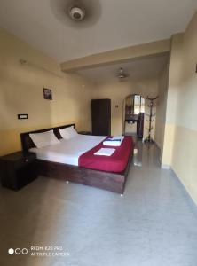 a bedroom with a large bed with a red blanket at Regina Residency Inn in Palolem