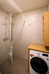 a washing machine in a bathroom with a shower at CITY PRESTIGE apartment Trencin in Trenčín