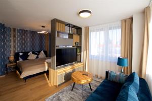 a living room with a bed and a blue couch at CITY PRESTIGE apartment Trencin in Trenčín