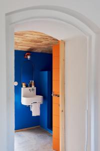 ein Badezimmer mit einem Waschbecken und einer blauen Wand in der Unterkunft Domaine La Ferme HI bride in Villelaure