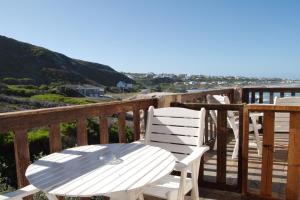 una mesa blanca y sillas en una terraza de madera en Agulhas Country Lodge, en Agulhas