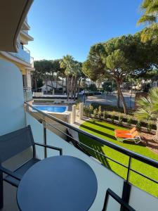 un balcón con mesas y sillas y una piscina en Aparthotel Las Palmeras Castelldefels, en Castelldefels