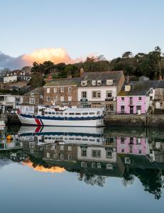 a boat is docked in the water next to houses at Padstow Escapes - Teyr Luxury Penthouse Apartment in Padstow