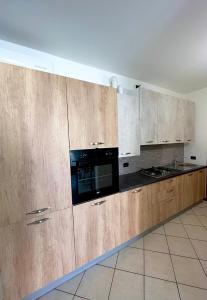 a kitchen with wooden cabinets and a black microwave at Residence la Lucciola in Lonato