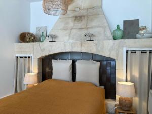 een slaapkamer met een oranje bed en 2 lampen bij L'Oasis de La Roquette in Arles