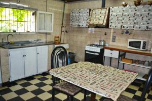 a kitchen with a table and a sink and a stove at Cabaña Ascensión-Caminos del Vino in Colonia Las Rosas