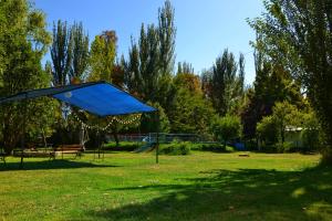 une tente bleue dans un parc avec une aire de jeux dans l'établissement Cabaña Ascensión-Caminos del Vino, à Colonia Las Rosas