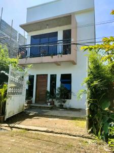 Casa blanca con balcón y puerta en Yannas transient house en Roxas City