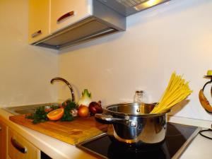 a pot on a stove in a kitchen with vegetables at Terramare in Castel di Tusa
